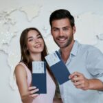 Premium Photo _ Portrait of joyful glad couple holding passport with flying tickets in hands